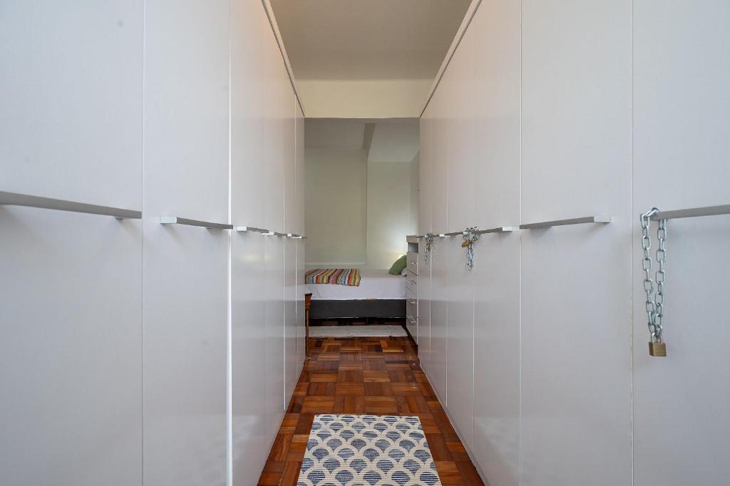 baño con paredes blancas y suelo de baldosa. en 2 quartos em Ipanema com vista para Lagoa e Cristo, en Río de Janeiro