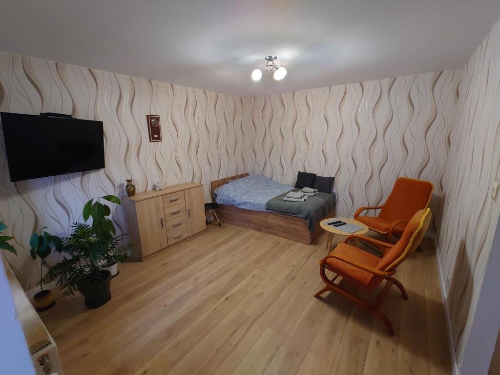a small bedroom with a bed and a chair at Emilka 2 in Suwałki