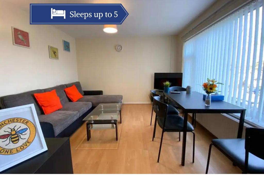 a living room with a couch and a table at Serene Apt in the Heart of Stretford in Manchester