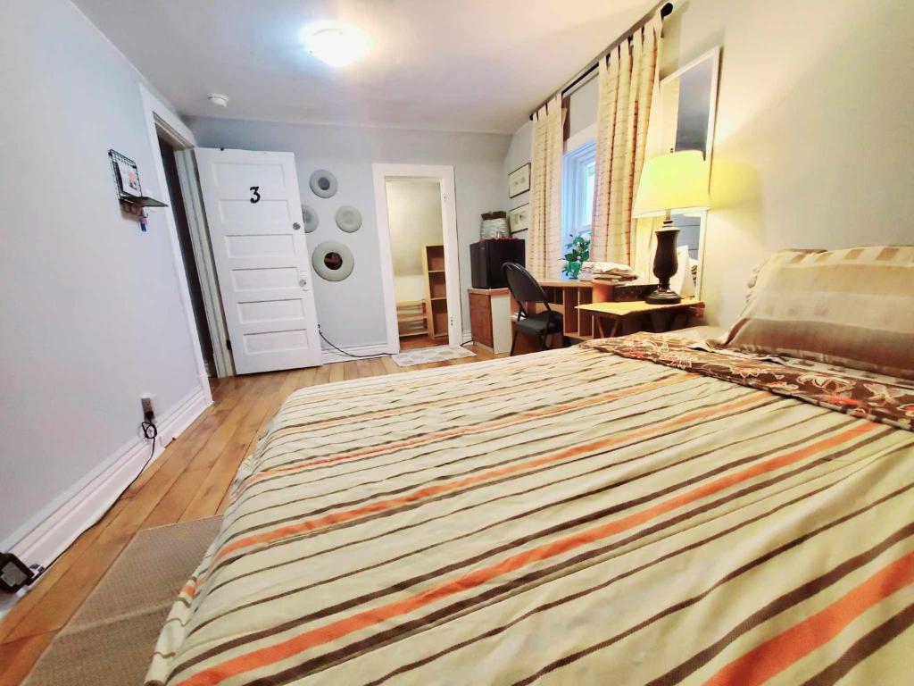 a bedroom with a bed and a desk and a door at Merj's Guest House in Wolesly in Winnipeg