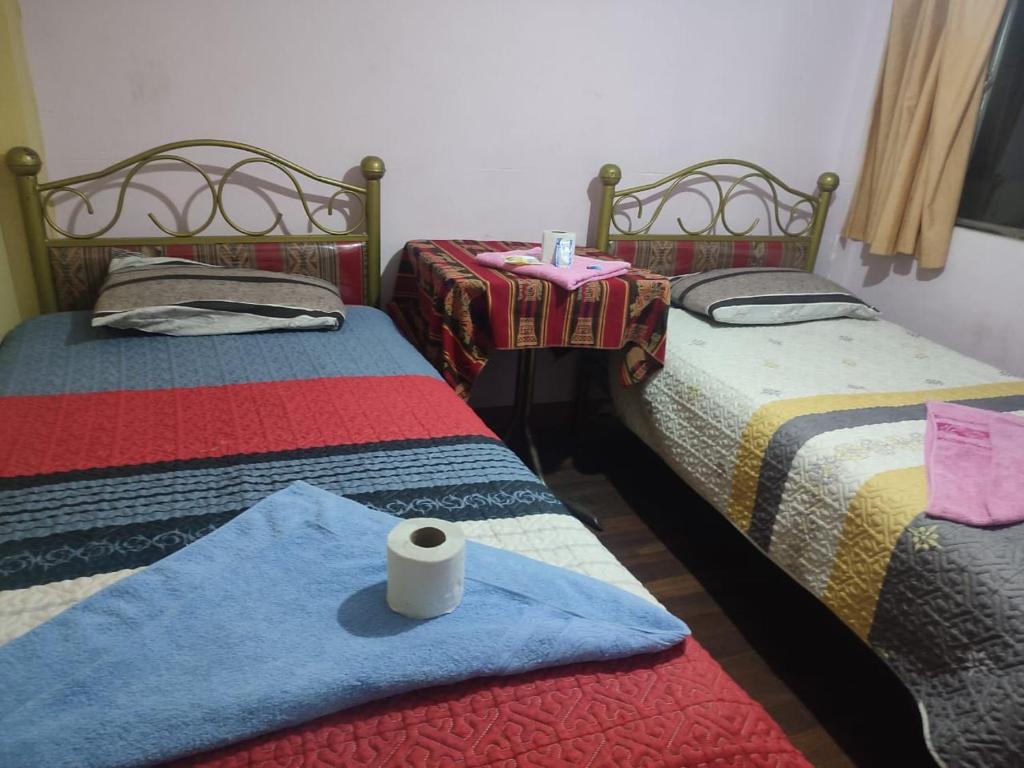 Cette chambre comprend 2 lits avec un rouleau de papier toilette. dans l'établissement Hostal Arco Iris, à Copacabana
