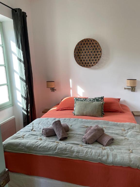 a bedroom with a large bed with two pillows on it at L'écrin de Mona au coeur de Lourmarin in Lourmarin