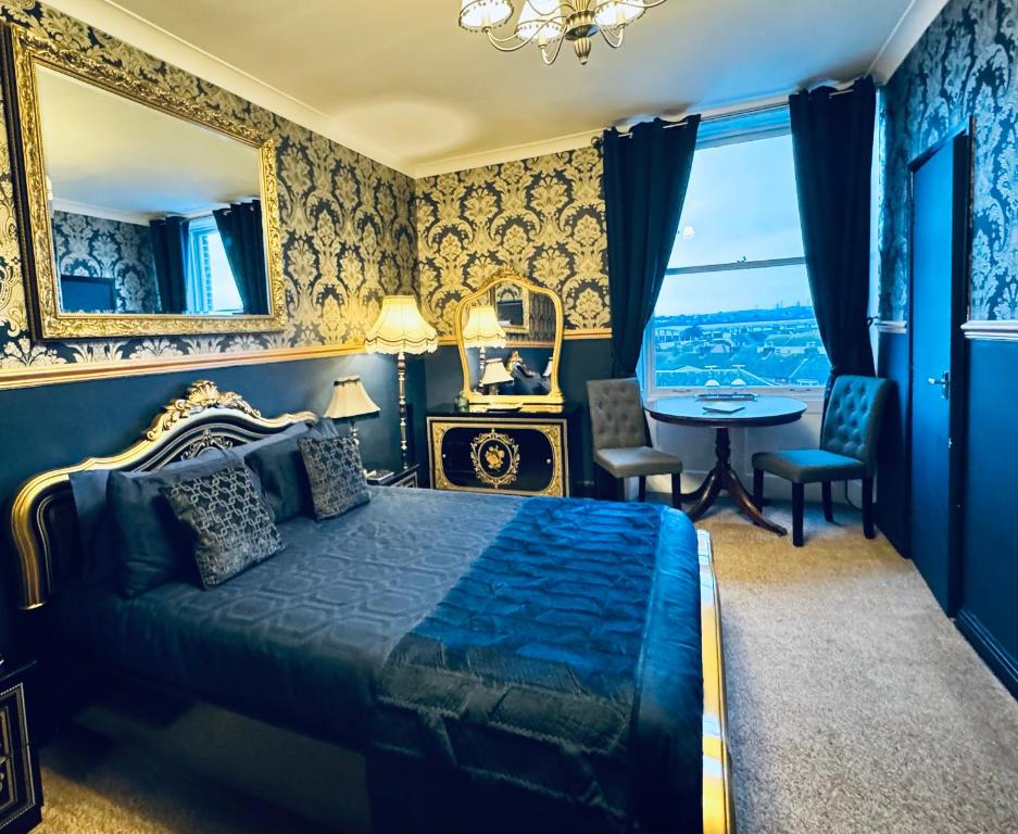 1 dormitorio con cama, mesa y ventana en The Angove en Weymouth