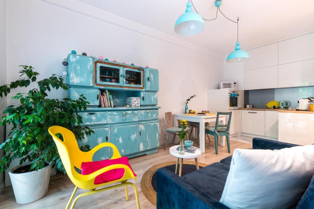 a living room with a couch and a yellow chair at Apartament Bulwary Łyna przy Starym Mieście in Olsztyn