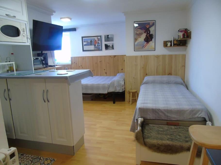 um quarto com uma cama e uma cozinha em Acogedor apartamento de montaña em Sierra Nevada