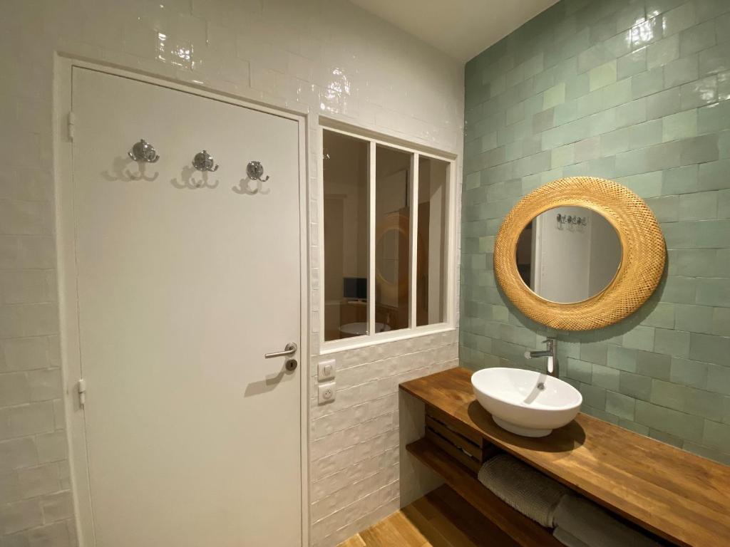 a bathroom with a sink and a mirror at Maison de ville d'architecte parking gratuit in Paris