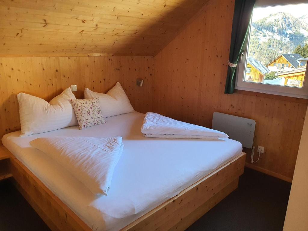 a bed in a wooden room with a window at Exclusive chalet in Hohentauern in ski area in Hohentauern