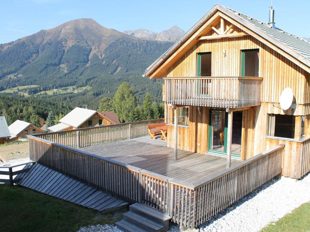 a house with a deck with mountains in the background at Exclusive chalet in Hohentauern in ski area in Hohentauern
