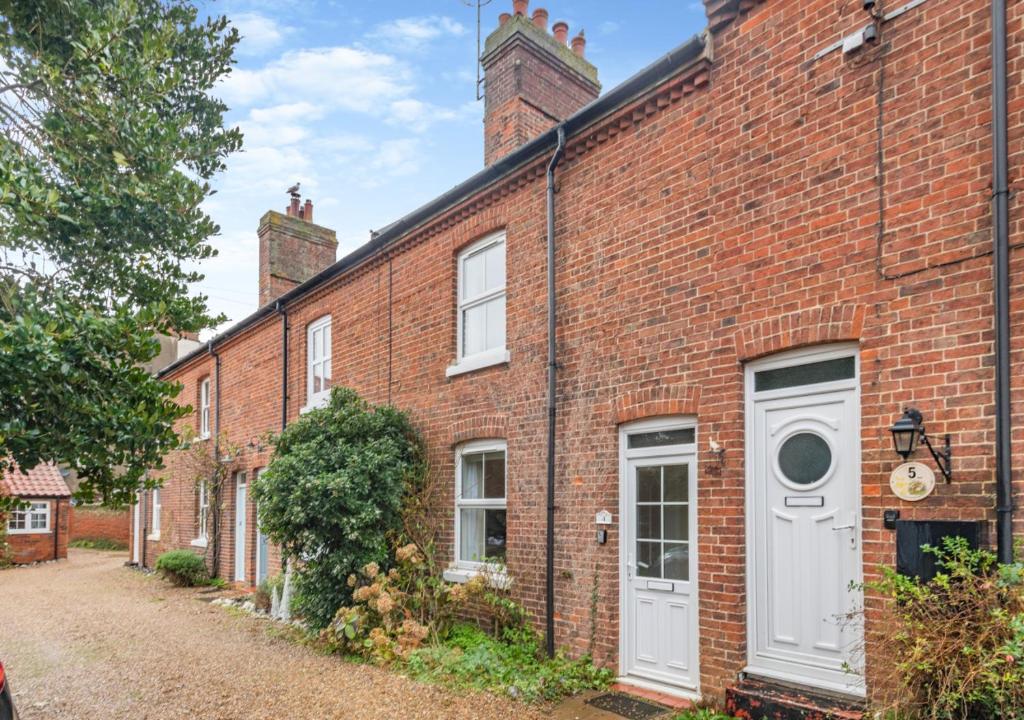 an exterior view of a brick building with a white door at Old Fishermans Cottage - East Runton in West Runton