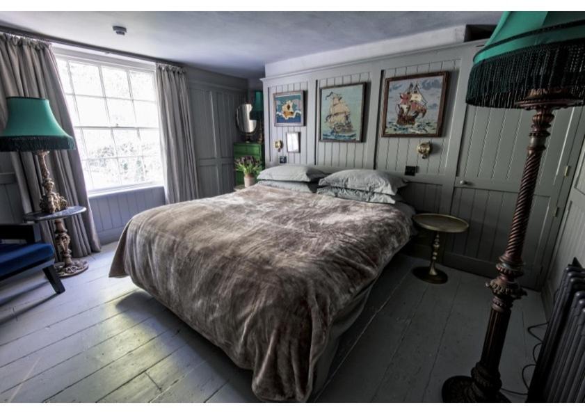 a bedroom with a large bed and a green lamp at House in Hastings in Hastings
