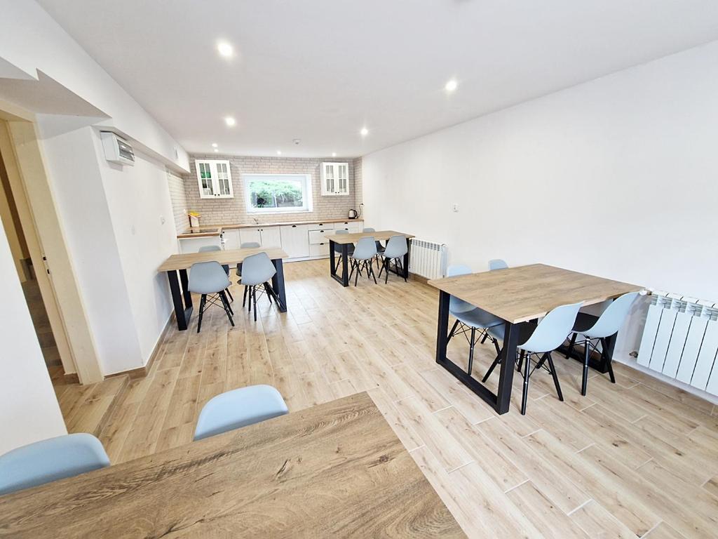 a room with tables and chairs and a kitchen at Noclegi Kielce - Dom nad rzeką - pokoje in Kielce