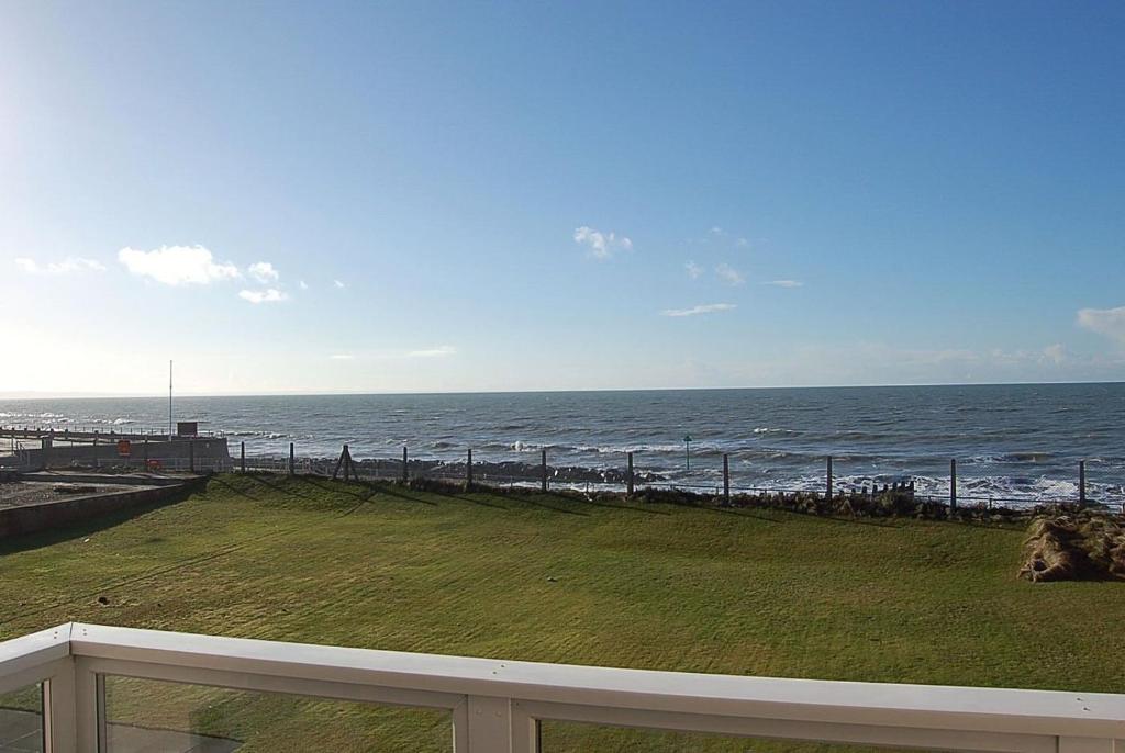 a view of the ocean from the balcony of a house at Ann's Beach House in Tywyn in Tywyn