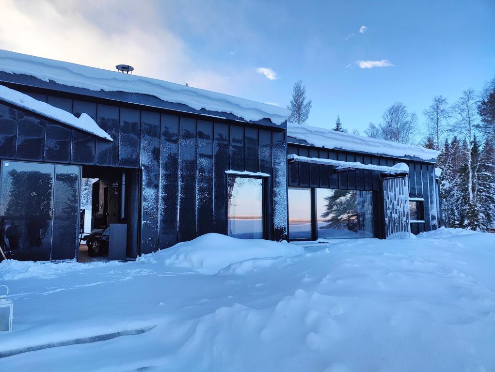 un bâtiment recouvert de neige avec beaucoup de neige dans l'établissement Arctic Aurora HideAway, à Rovaniemi