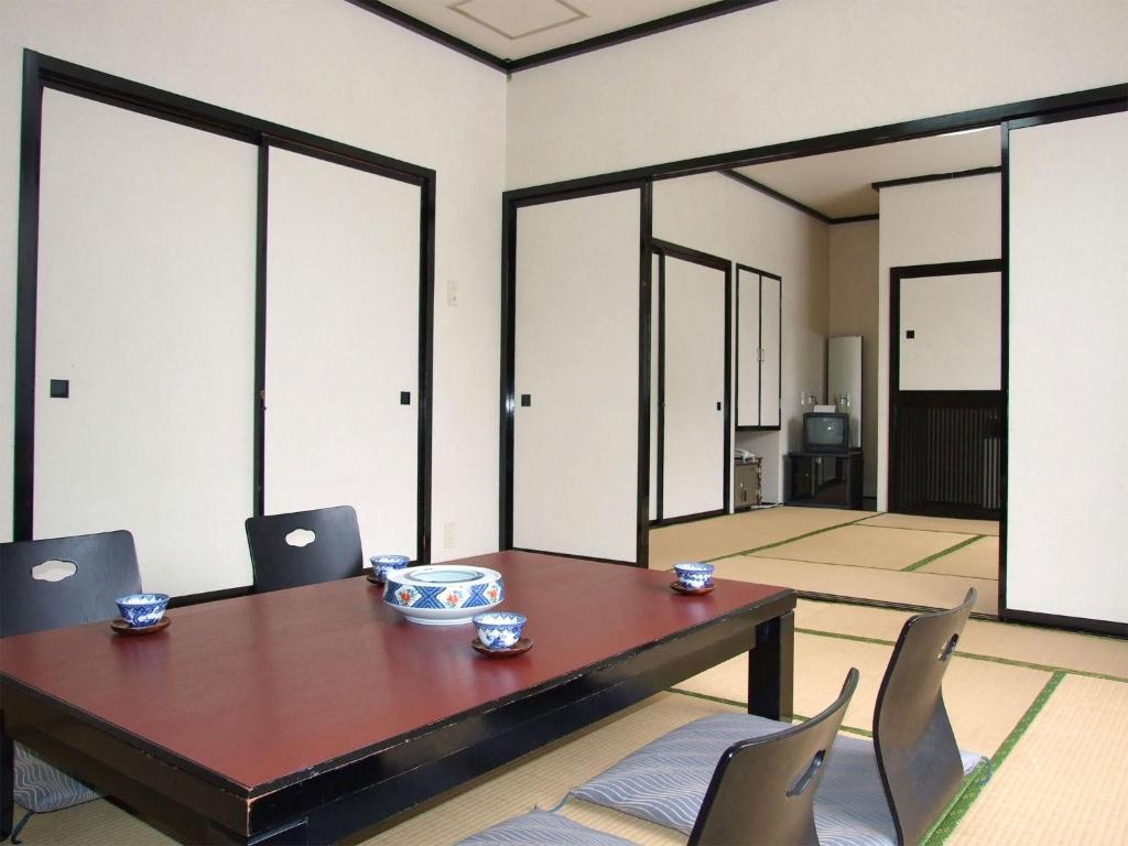 Oshuku Onsen Hotel Uguisu - Vacation STAY 27315v في Shizukuishi: غرفة طعام مع طاولة وكراسي