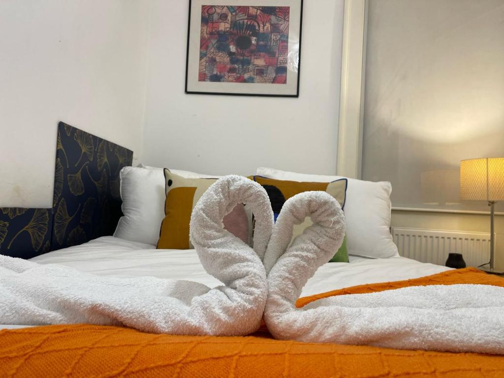 a pair of swans made out of towels on a bed at Central Point apartment in London