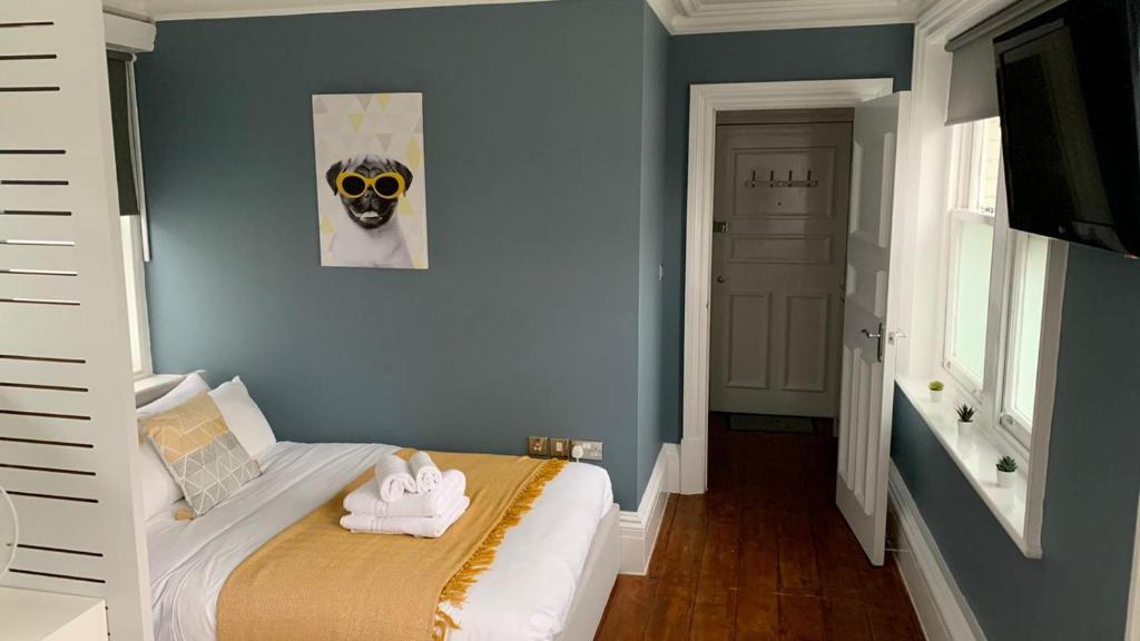 a bedroom with a bed with a dog picture on the wall at Ideal location! Studio flat in heart of the city in Bristol