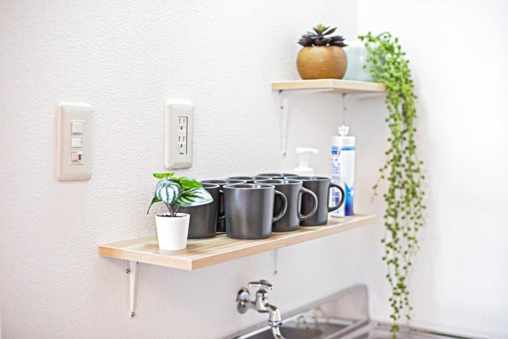 a shelf over a sink with pots and plants at Tenmabashi Home in Osaka - Vacation STAY 16207 in Osaka