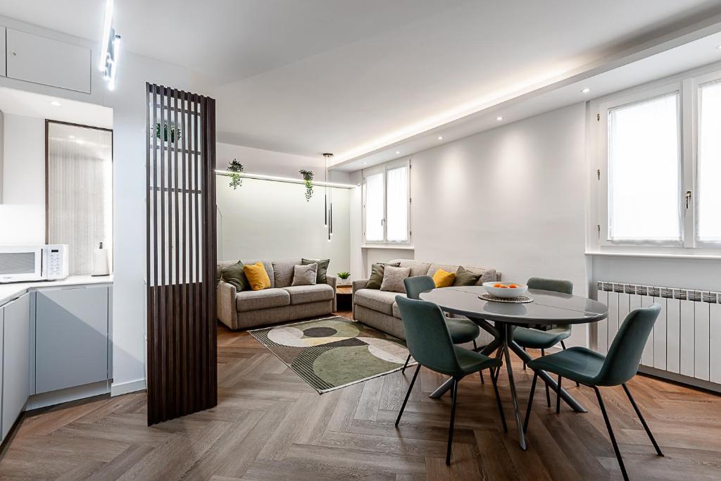 a living room with a table and a couch at StayEasy Argelati40 - Penthouse with 2 bedrooms, 2 bathrooms and terrace - Navigli in Milan
