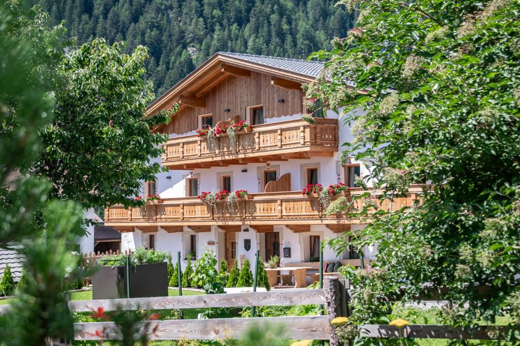 a building with a balcony with flowers on it at Mesnerhof in Valles