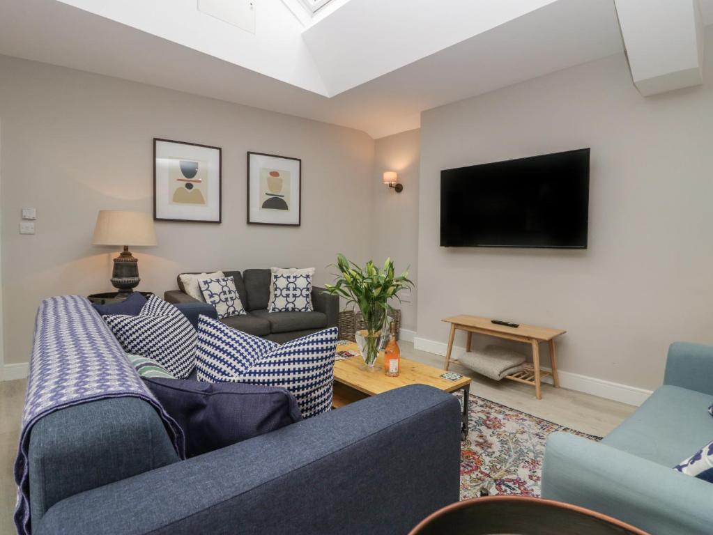 a living room with couches and a flat screen tv at Helton Fell in Kendal