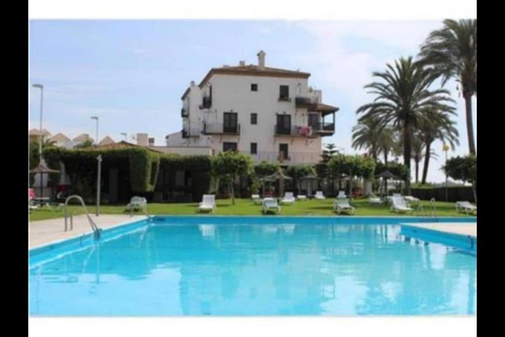a large swimming pool in front of a large house at PUSHE Playa Granada Beach & Golf 24 in Motril