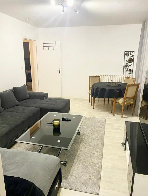 a living room with a couch and a table at Appartement à 5mn du centre ville Compiegne in Compiègne