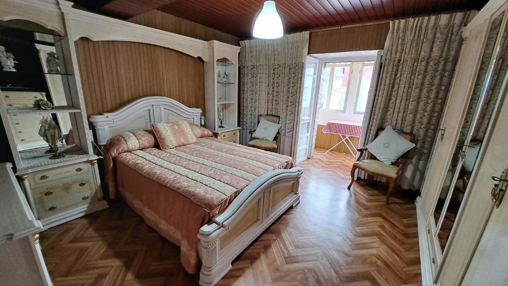 1 dormitorio con 1 cama y 1 silla en una habitación en CUCA, en Muxía