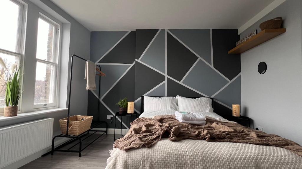 um quarto com uma grande parede cinzenta e uma cama em Modern Apartment in Kings Cross em Londres