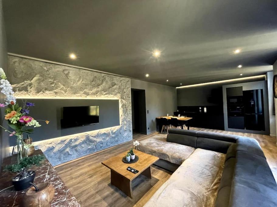 un salon avec un canapé et une table dans l'établissement Suite Anela, à Saint-Claude