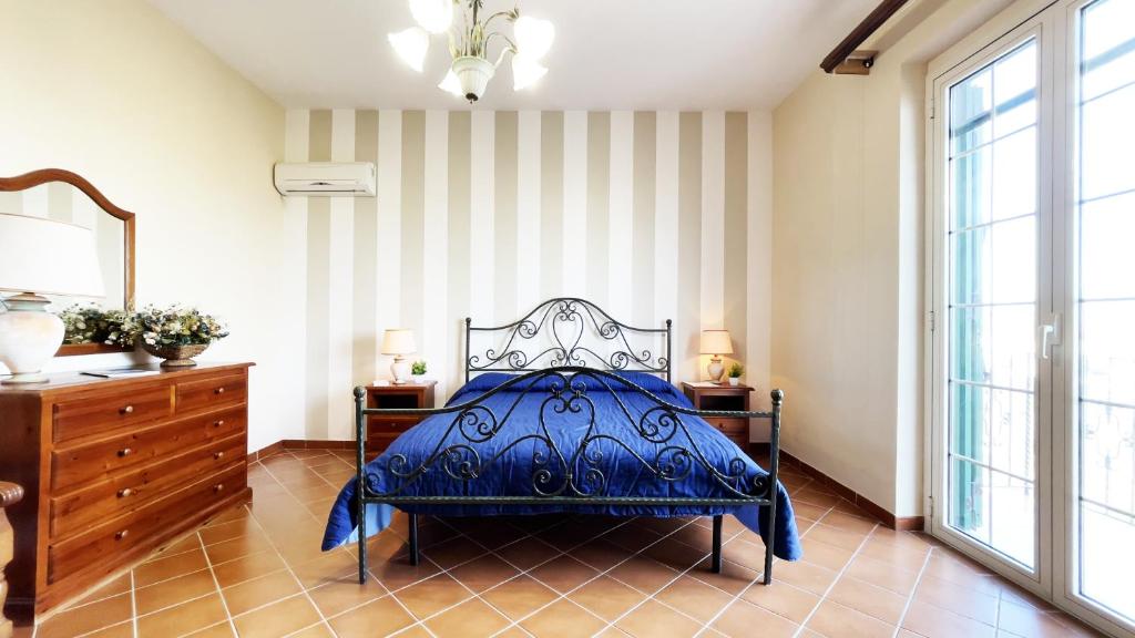 ein Schlafzimmer mit einem blauen Bett und einer Kommode in der Unterkunft Country Sicily Home in Favara