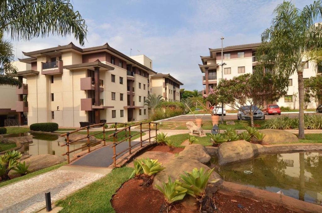 巴西利亞的住宿－L209 Apto em resort beira lago com TV Smart，享有带池塘的公寓大楼的景色