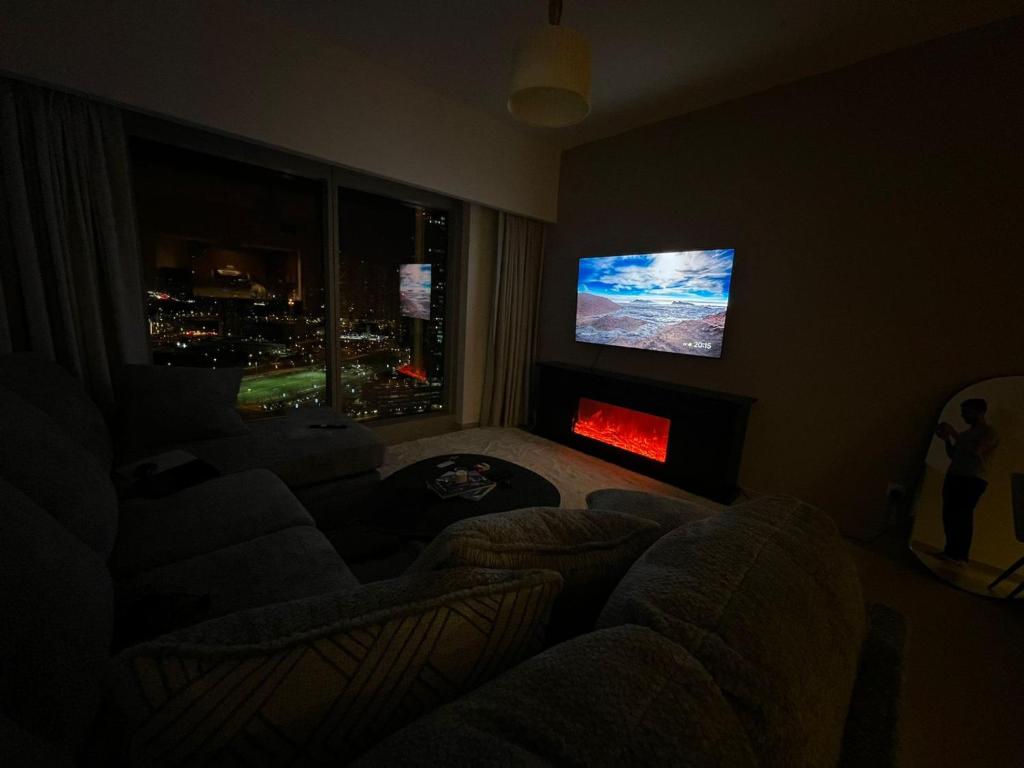 a living room with a couch and a flat screen tv at Dinar Home in Abu Dhabi