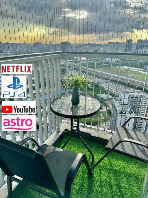 a table and chairs on a balcony with a view at Sunset View at Modern Home in Kuala Lumpur