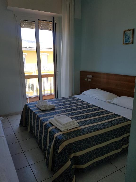 una camera da letto con un letto e asciugamani di acapulco hotei a Rimini