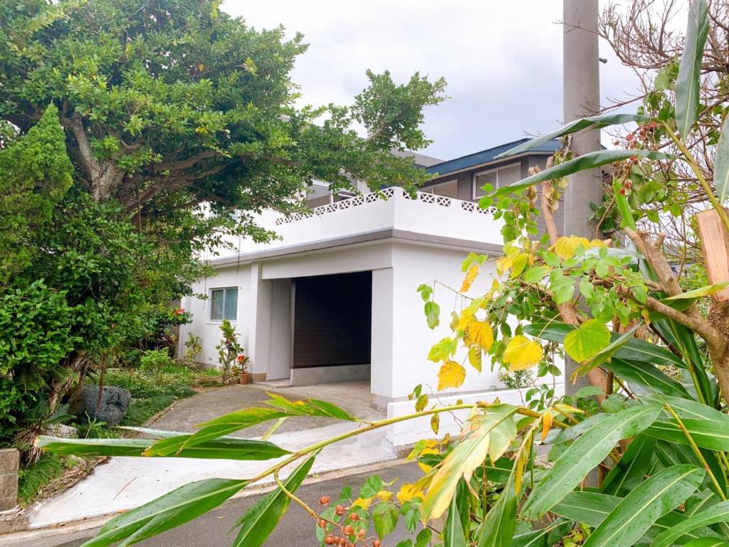 a white house with a garage at Amami North Mangrove Inn - Vacation STAY 90032v in Amami