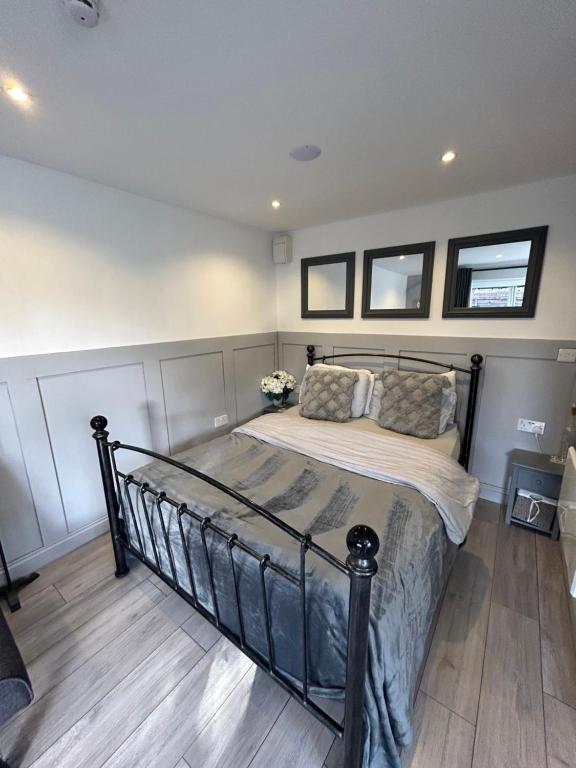 a bedroom with a metal bed with two windows at The Studios in Hempstead