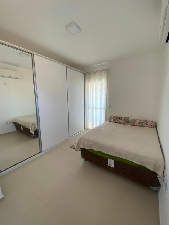um quarto com uma cama e um espelho grande em Casa 02 - Aconchego em Caucaia