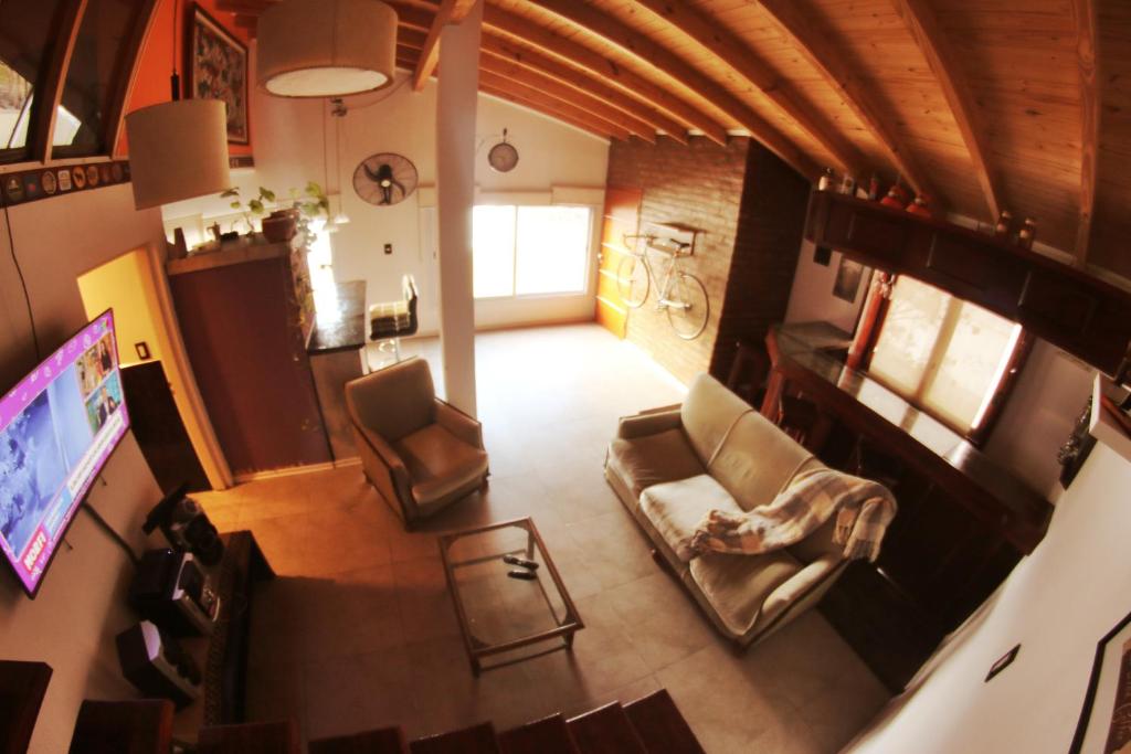 una vista aérea de una sala de estar con sillas y TV en Departamento Loft completo, cómodo y luminoso. en Neuquén