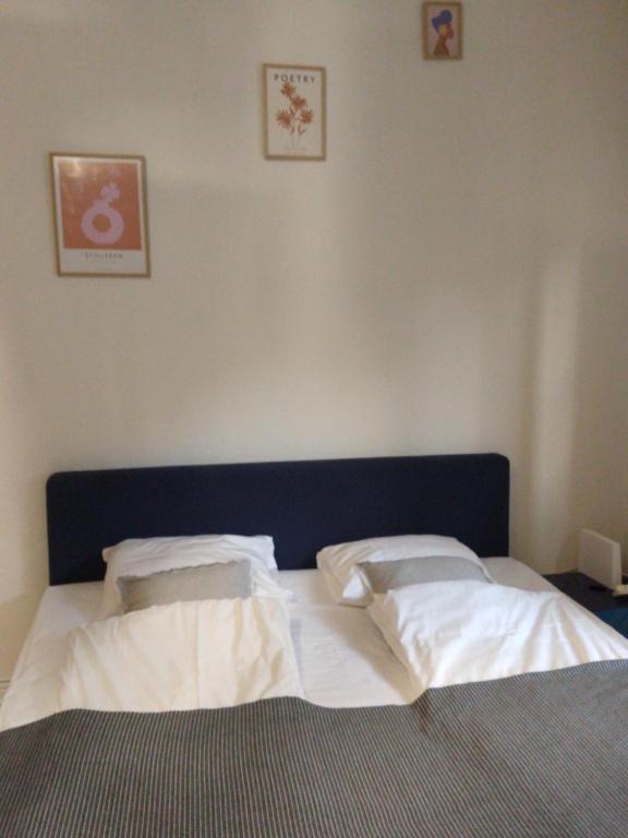 1 dormitorio con 1 cama con sábanas y almohadas blancas en COZY STUDIO CENTRAL, en Helsingborg