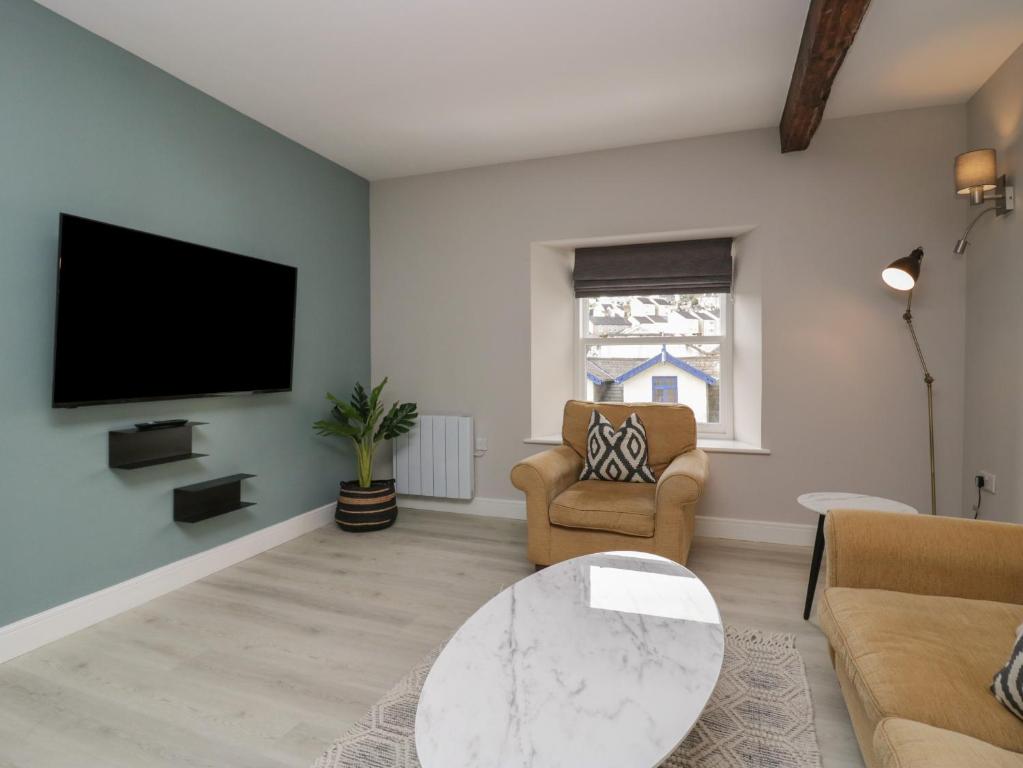 sala de estar con TV, sofá y mesa en Windermere, en Kendal