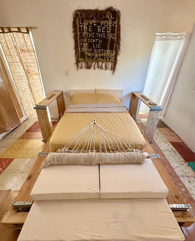 2 camas en una habitación con un cartel en la pared en UcúLila, en Sisal