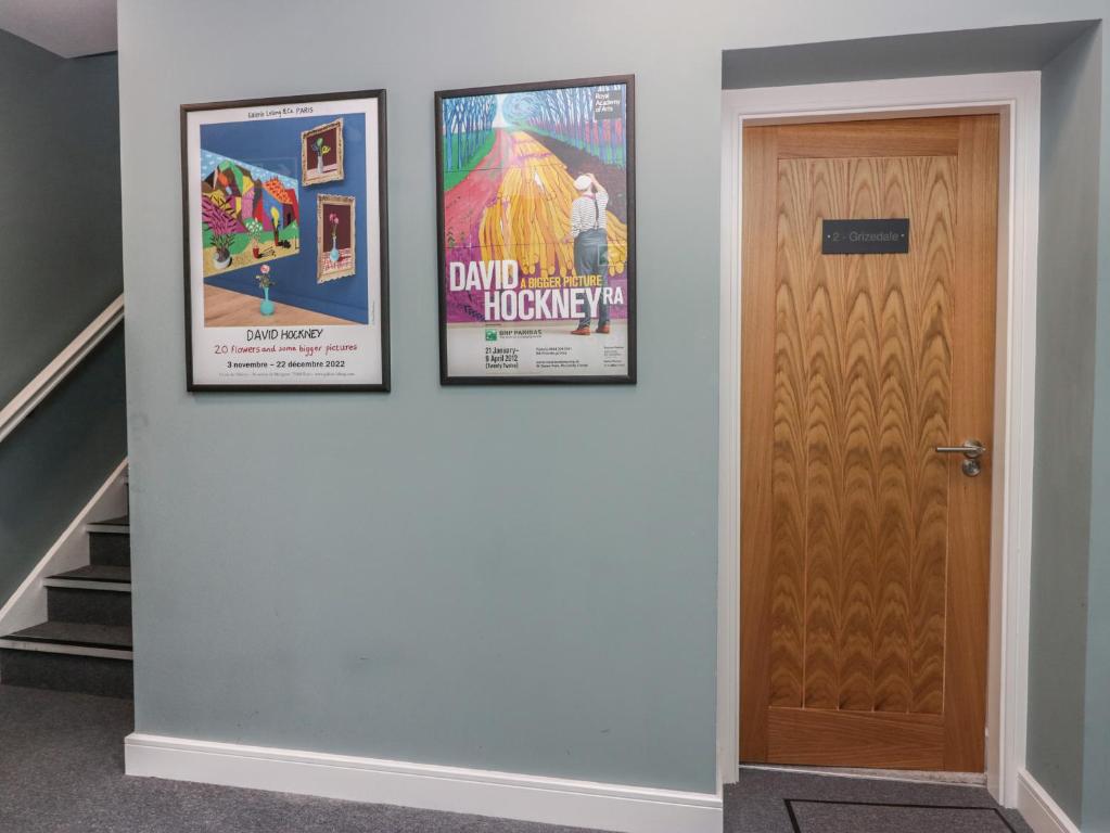 three posters on a wall next to a door at Grizedale in Kendal