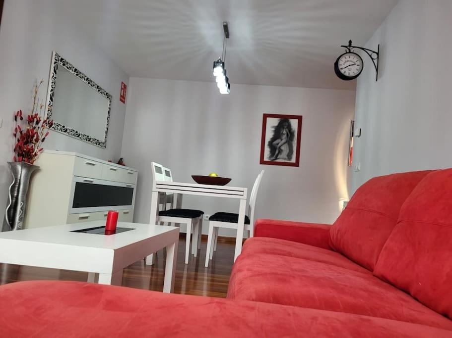 sala de estar con sofá rojo y mesa en Apto. Vista Bahía Santander, en Pontejos