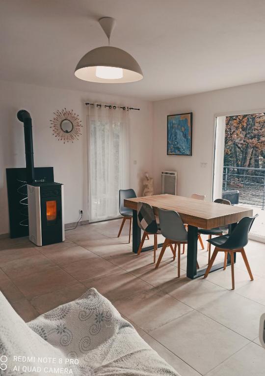 - une salle à manger avec une table et un poêle à bois dans l'établissement Un coin de campagne, à Le Puy-Sainte-Réparade