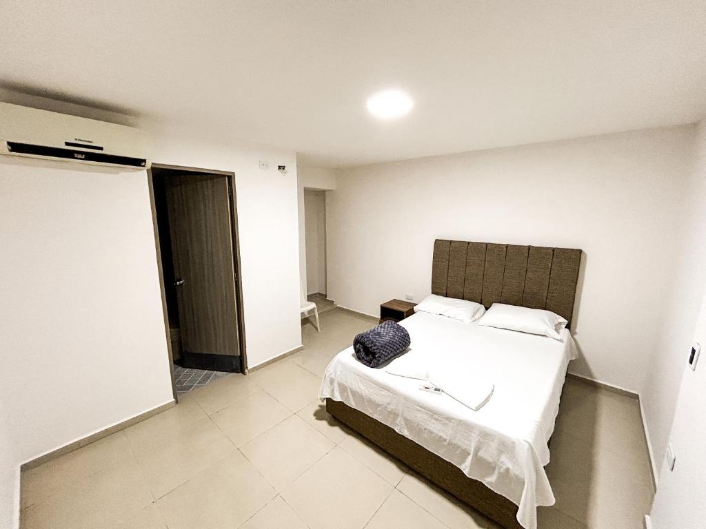 1 dormitorio con 1 cama y puerta a una habitación en Hotel y Restaurante Oasis CTG en Cartagena de Indias