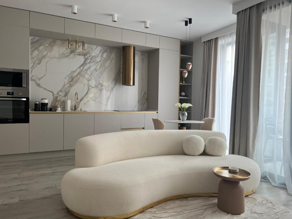 uma sala de estar com um sofá branco e uma mesa em Harmony property WIN HERASTRAU em Bucareste