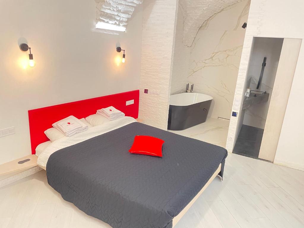 a bedroom with a bed with a red hat on it at Red & Yellow Old Town in Lviv