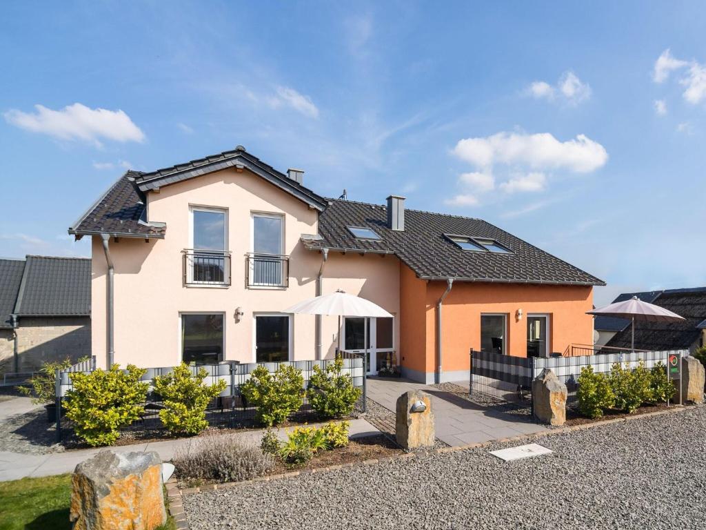 une maison avec une clôture devant elle dans l'établissement Holiday home with terrace near volcanic lakes, à Ellscheid