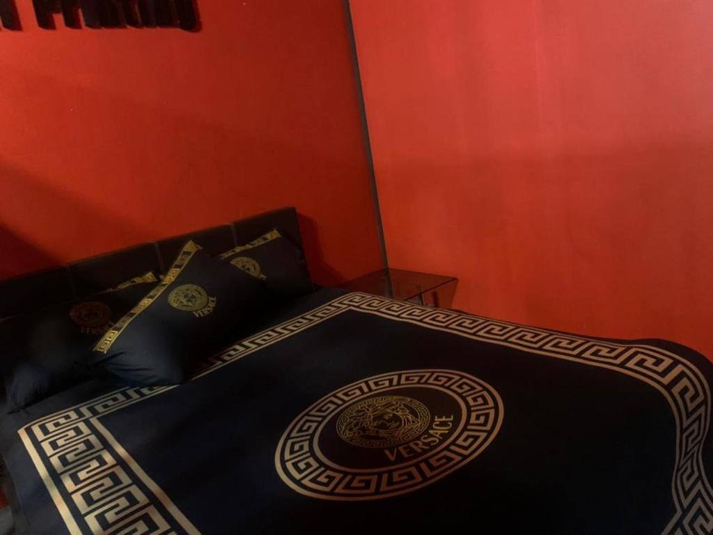 een bed met een zwart dekbed en kussens bij Hanna homestay studio in Alor Setar