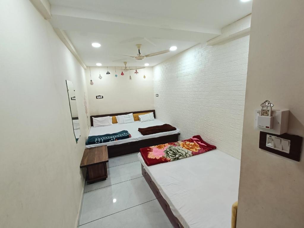 a small room with two beds in it at Hotel ST INN in Ujjain